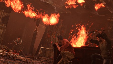 Sully and the player crouch behind cover in a gunfight inside a burning chateau